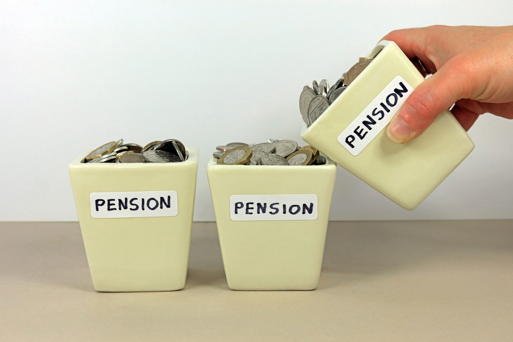 A Hand Tipping A Pension Pot In To Another. Consolidating Multiple Pensions Concept.