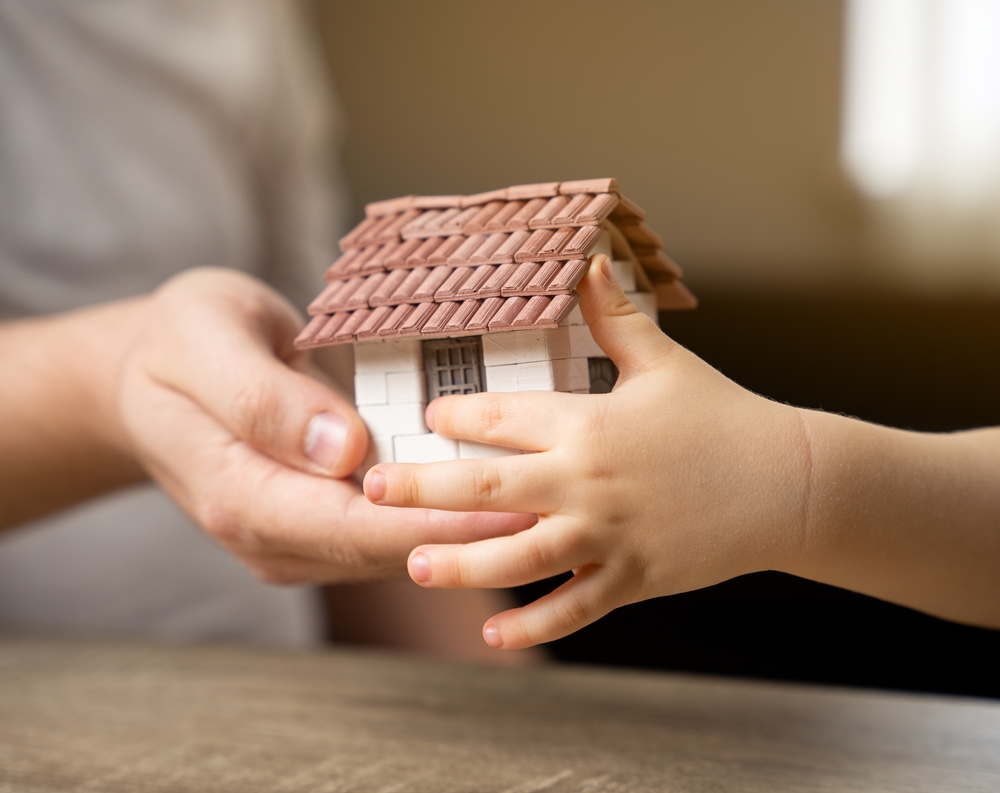 A father gives his son a small house. The concept of transfer of property and inheritance. Real estate. housing as a gift, apartment or house