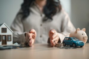 Person managing personal finances by allocating budget across assets like home, car and savings, illustrating expense planning, wealth management and financial control.